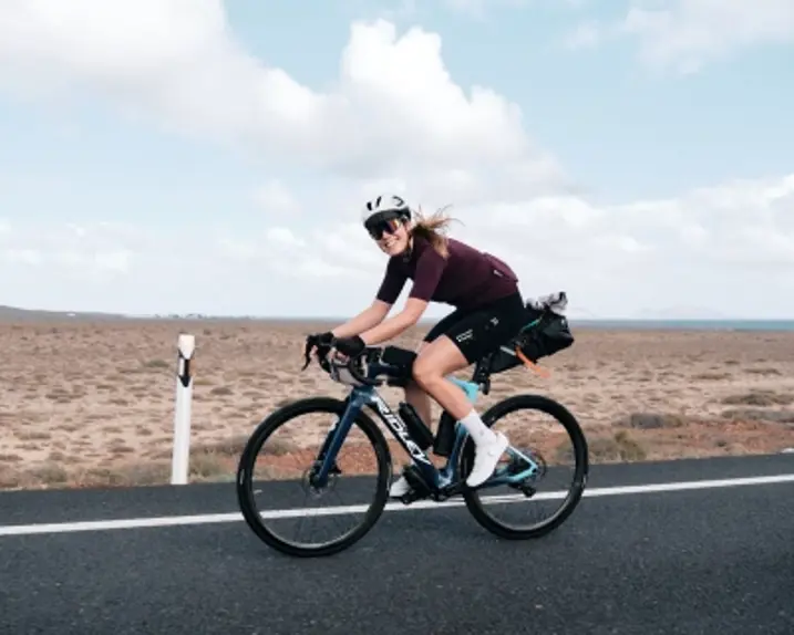Die Influenzerin Univorncycling wurde auf dem Fahrrad abgelichtet. Sie trägt eine Fahrrandbrille, einen Helm und das passende Raddress  schwarz.